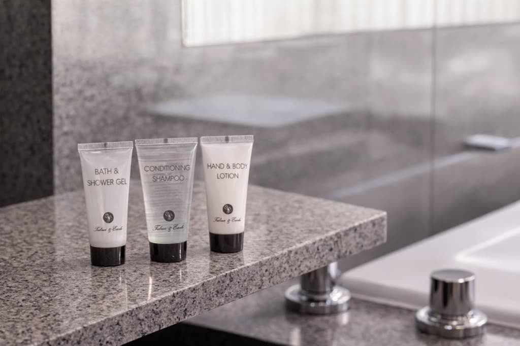 Luxury guest amenity tubes on a hotel bathroom counter